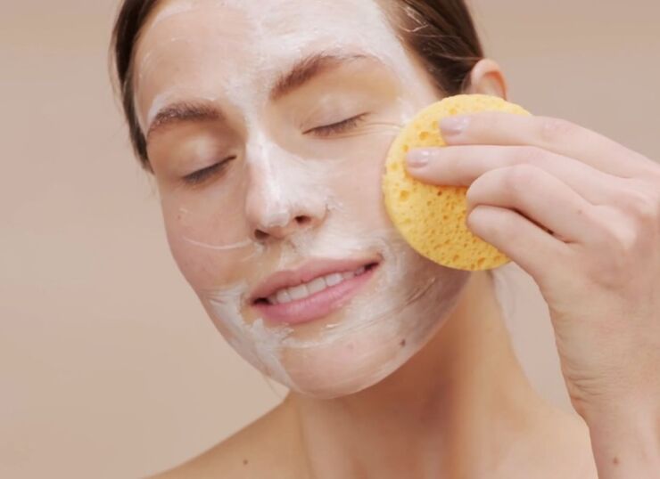 devojka čisti lice sa sunđerom