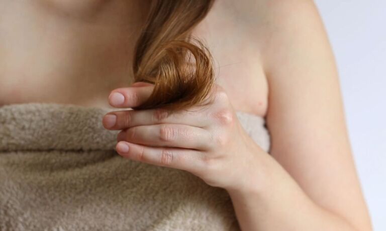 devojka gleda u pramen svoje tanke kose