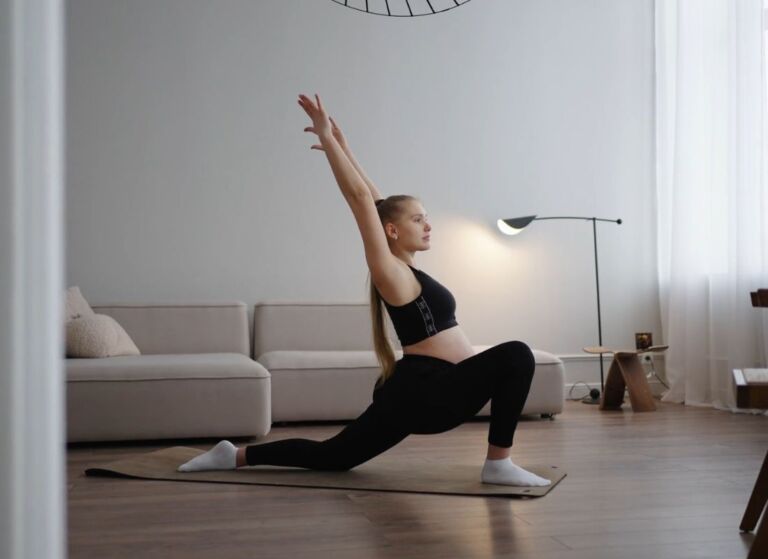 trudna devojka radi vežbe za istezanje kod kuće