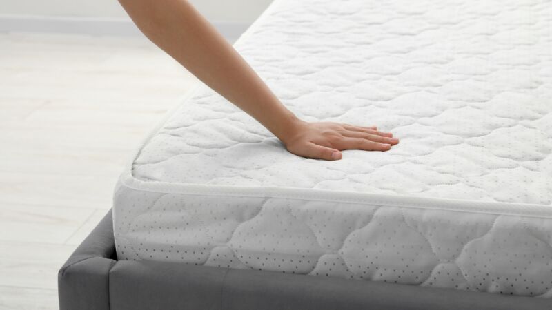 Ruka pritiska površinu dušeka kako bi se proverila mekoća i podrška
