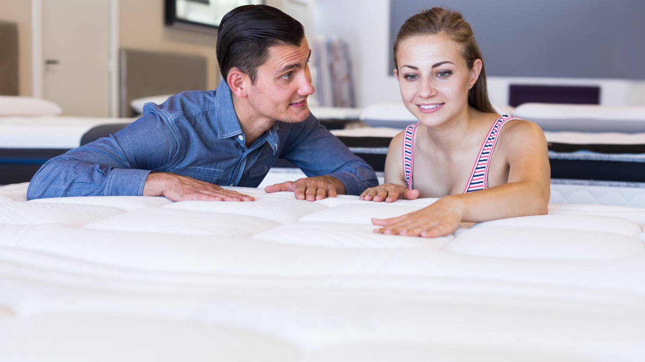 Par u salonu isprobava dušek dodirom kako bi procenili udobnost i podršku