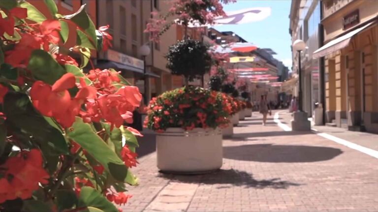 Pešačka ulica ukrašena cvećem i suncobranima u Bosni i Hercegovini.