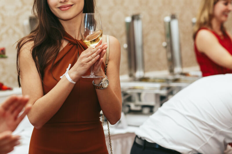 Žena u elegantnoj midi haljini na svadbenoj proslavi